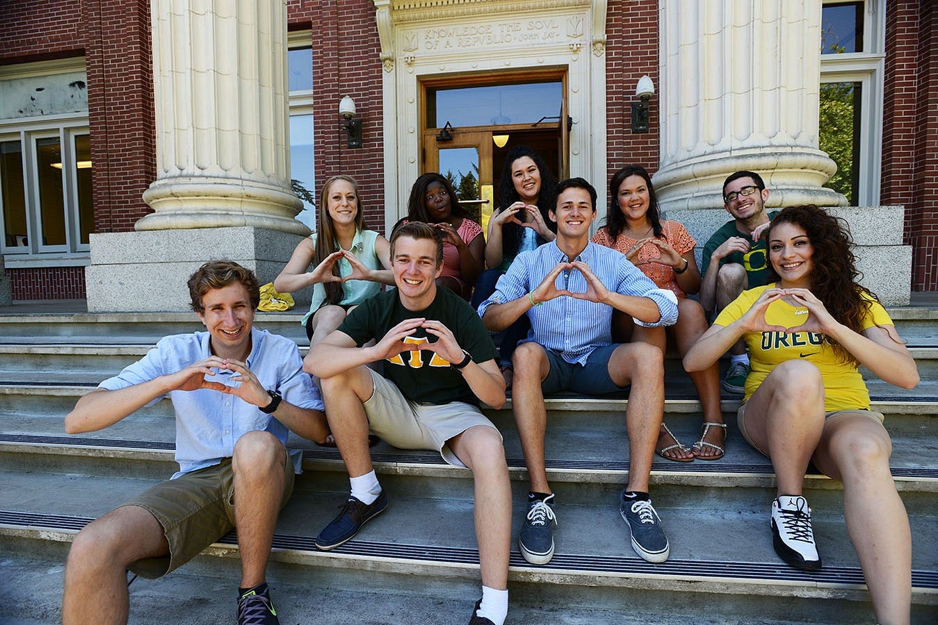 Students sitting together throwing an O